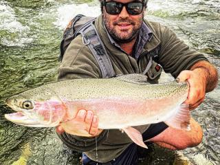 An Angler fly fishing for trout on the Ahuriri river, surrounded